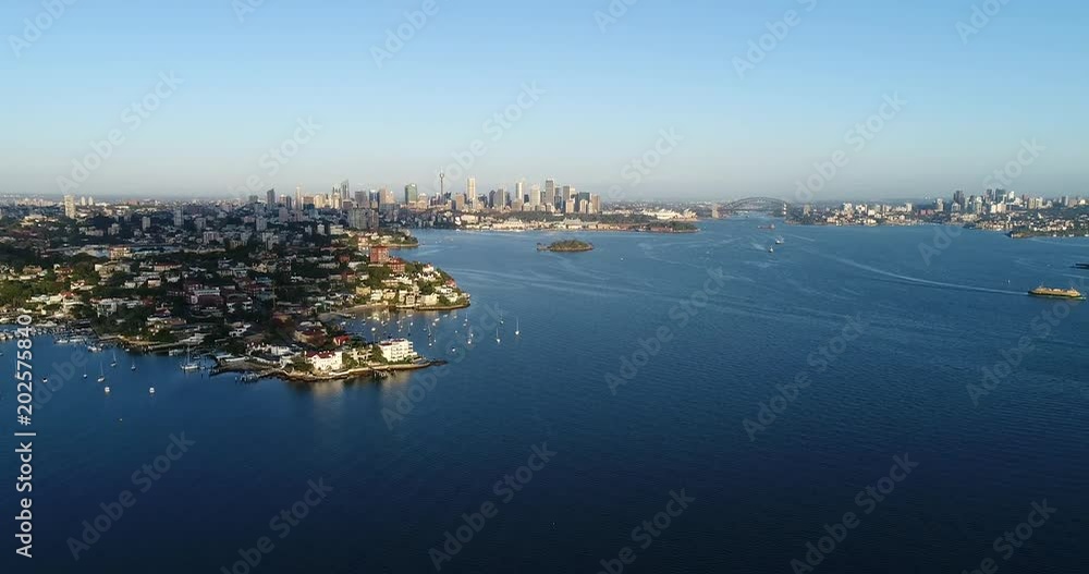Magnificent view of Sydney city CBD skyline beyond blue waters of Sydney harbour in aerial panning over Rose bay to shark island.
Magnificent view of Sydney city CBD skyline beyond blue waters of Sydney harbour in aerial panning over Rose bay to shark island.