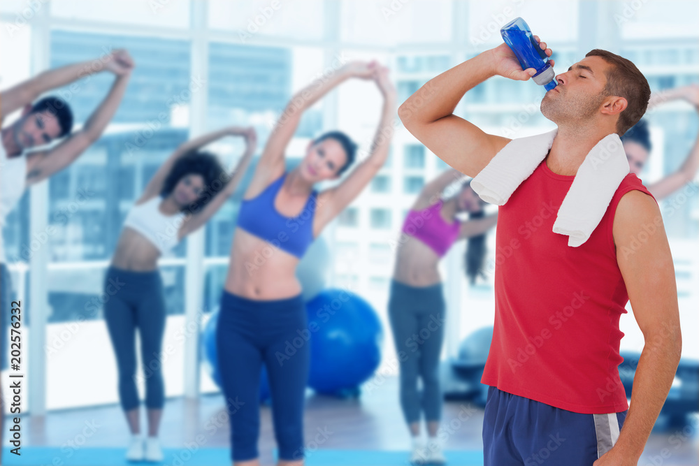 Composite image of fit man drinking water from bottle