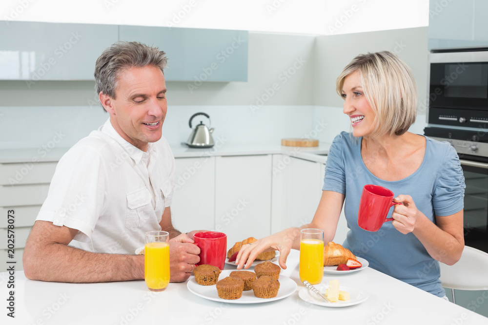 Happy couple having breakfast in kitchen Happy couple having breakfast in kitchen