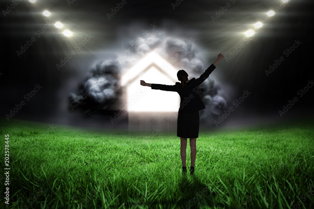 Φωτογραφία Excited businesswoman cheering against football pitch with bright lights
