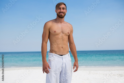 Portrait of smiling shirtless man at beach