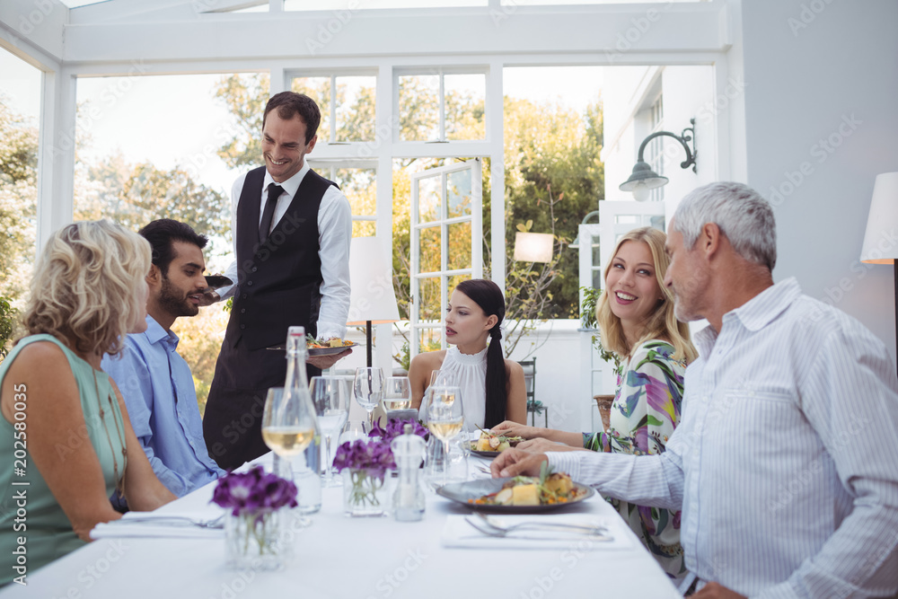 Waiter serving food to customers Waiter serving food to customers
