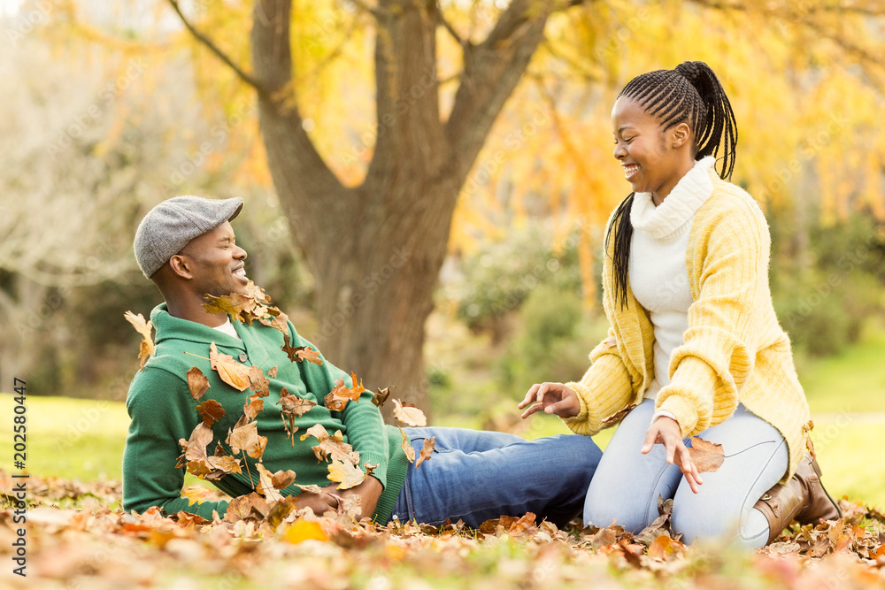View of a young smiling couple in leaves View of a young smiling couple in leaves