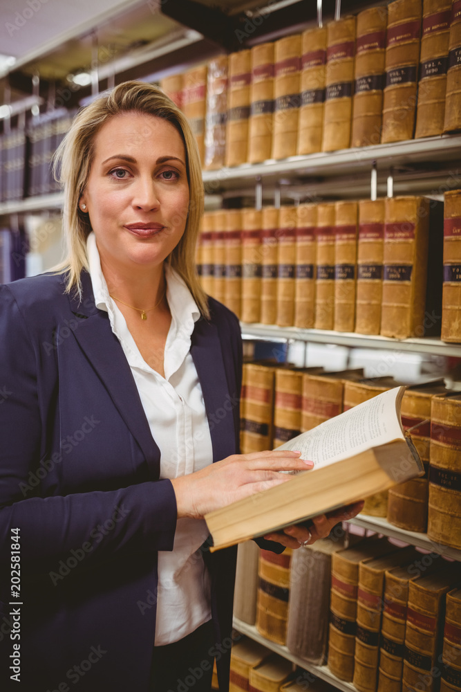 Woman reading a book from shelf standing Woman reading a book from shelf standing