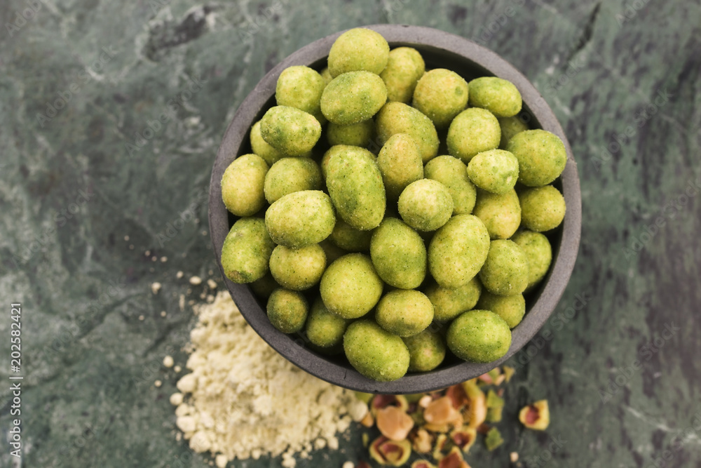 Pile of wasabi coated peanuts in bowl Pile of wasabi coated peanuts in bowl