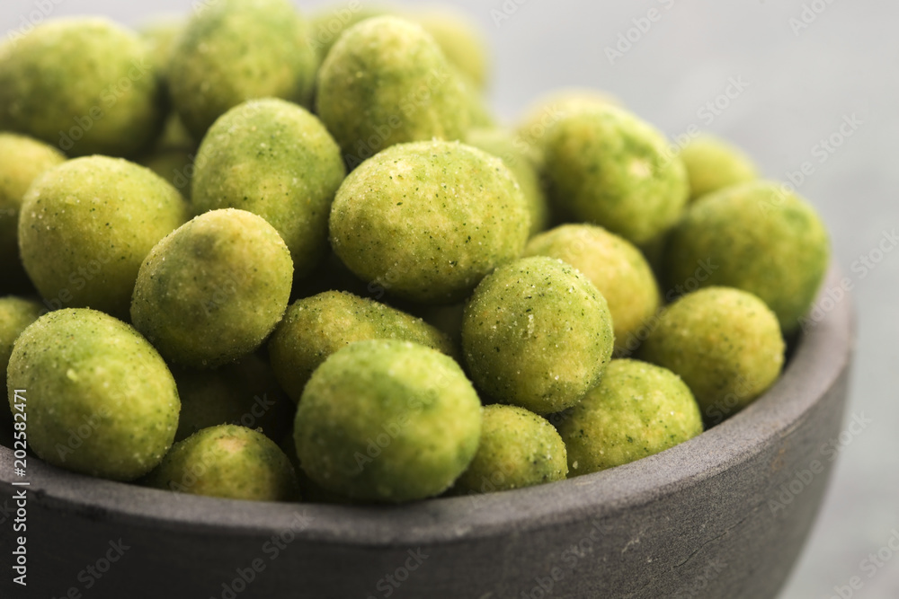 Pile of wasabi coated peanuts in bowl Pile of wasabi coated peanuts in bowl