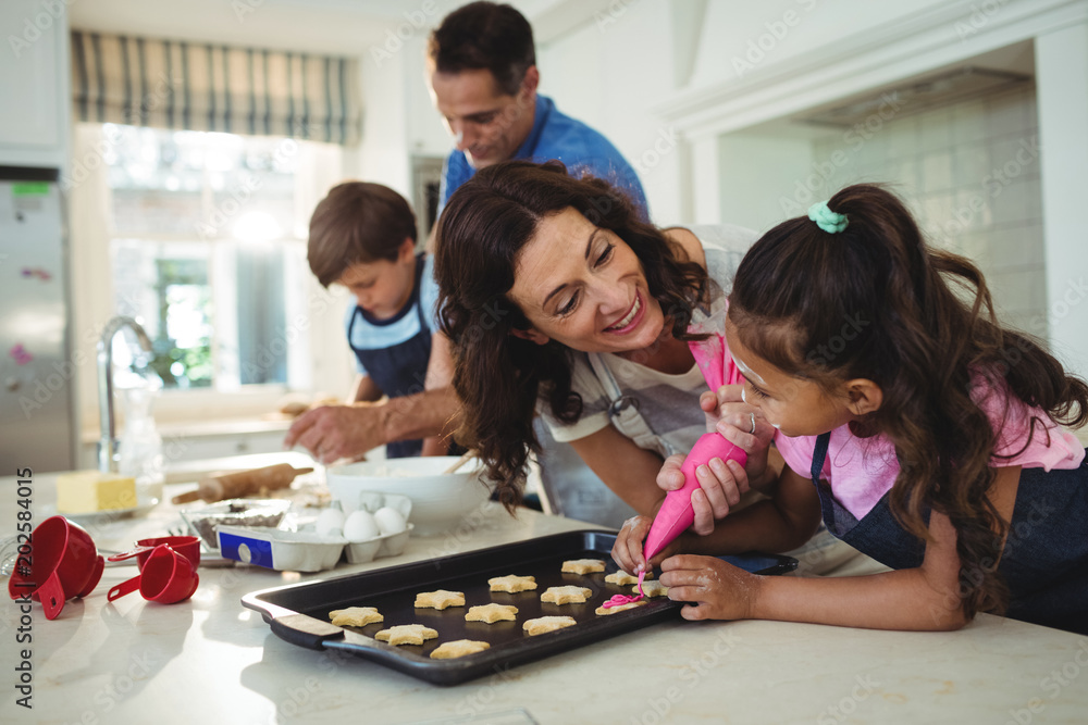 Happy family preparing cookies in kitchen Happy family preparing cookies in kitchen