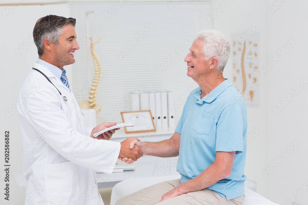 Male doctor and senior patient shaking hands Male doctor and senior patient shaking hands