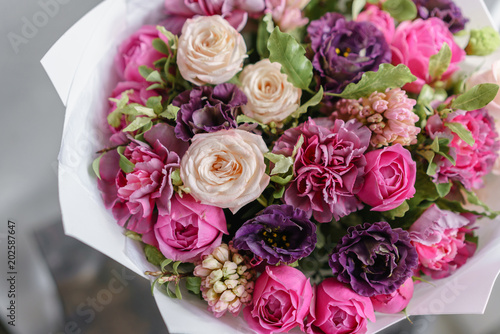 purple and pink bouquet of beautiful flowers on wooden table. Floristry concept. Spring colors. the work of the florist at a flower shop. Vertical photo