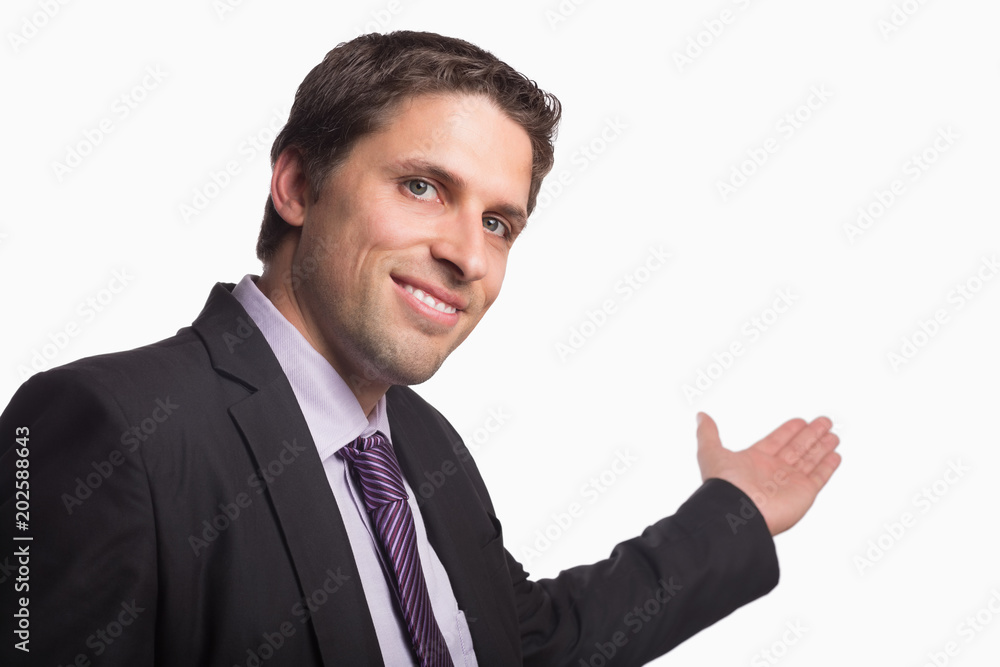 Businessman giving a welcome gesture against white background Businessman giving a welcome gesture against white background