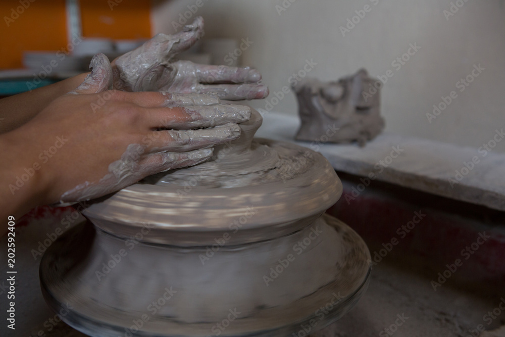 Hands of female potter molding a clay