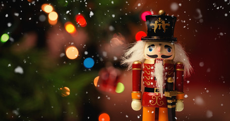 Snow falling against close-up of nutcracker toy solider christmas decoration