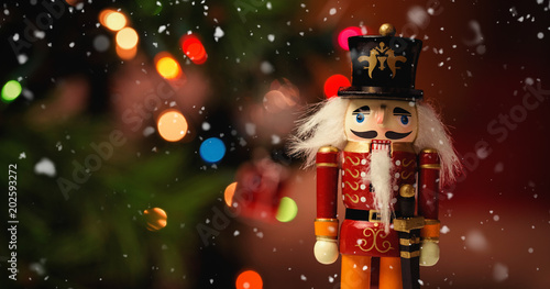 Snow falling against close-up of nutcracker toy solider christmas decoration