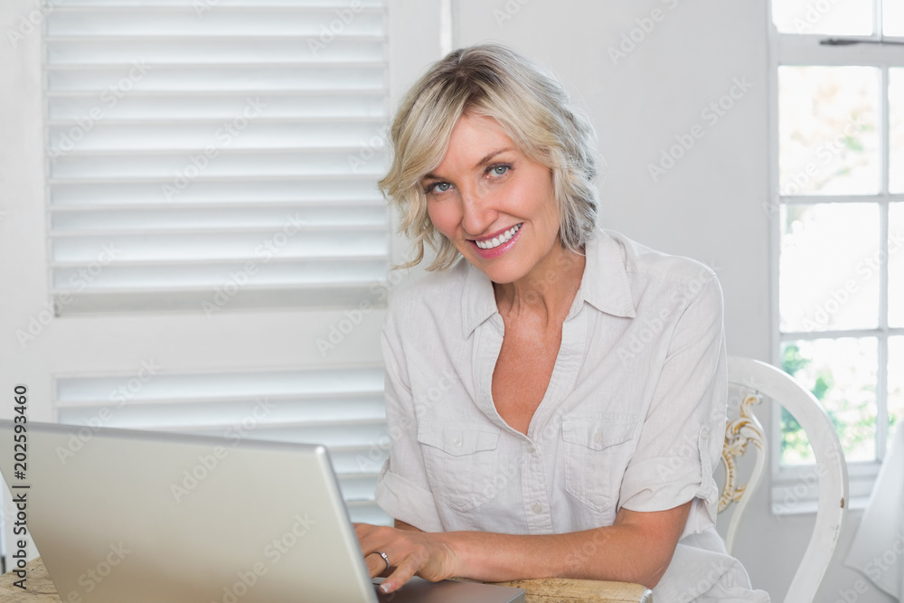 Smiling mature woman using laptop at home Smiling mature woman using laptop at home
