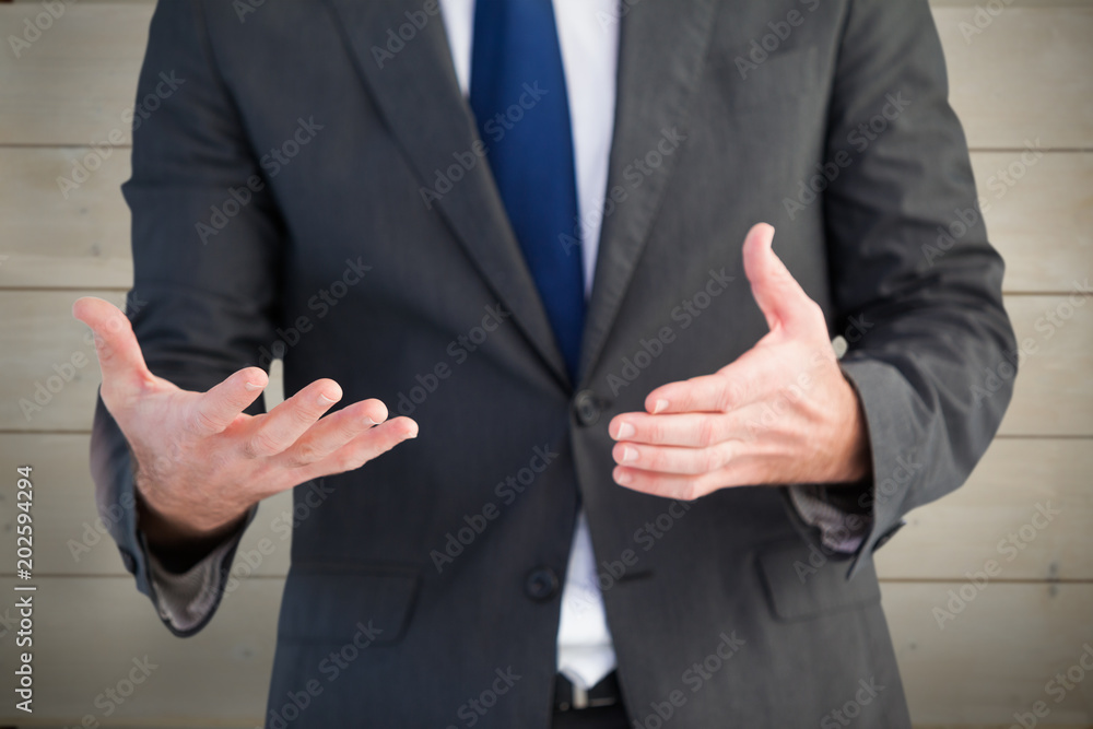 Handsome businessman presenting with hands against bleached wooden planks background
