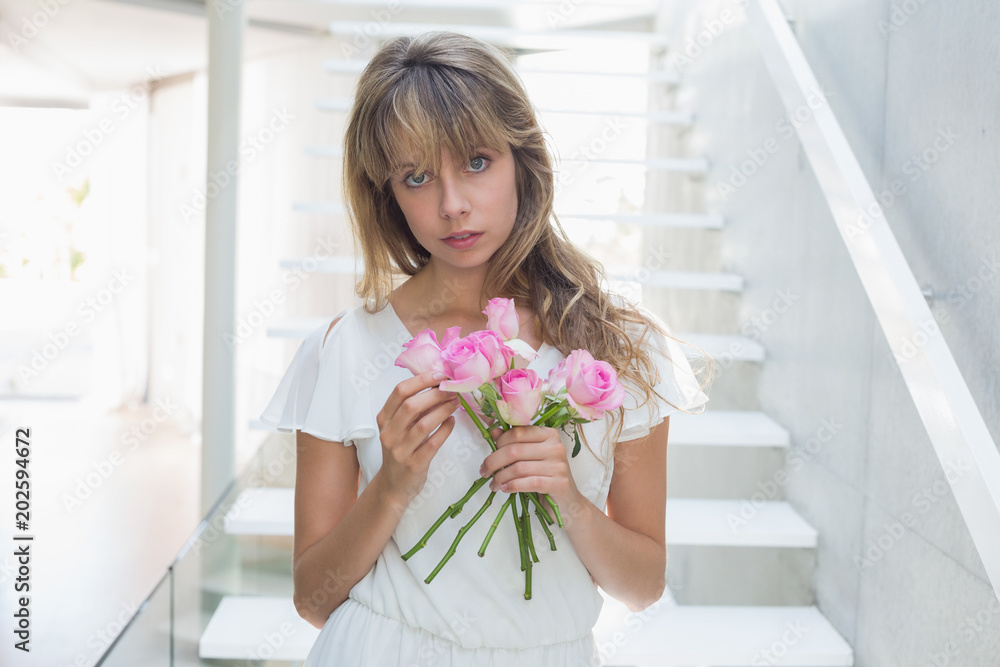Φωτογραφία Portrait of a beautiful sad woman with flowers on stairs