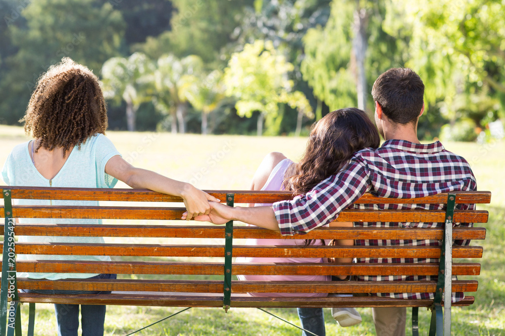 Bild auf Leinwand Lonely woman sitting with couple in park