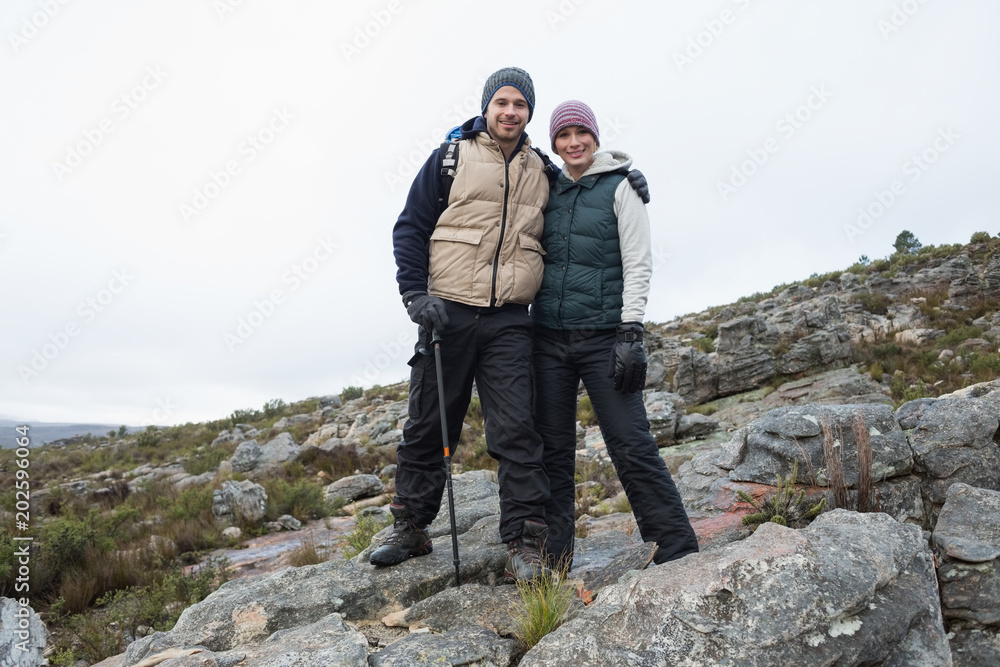 Couple standing on rocky landscape against the sky