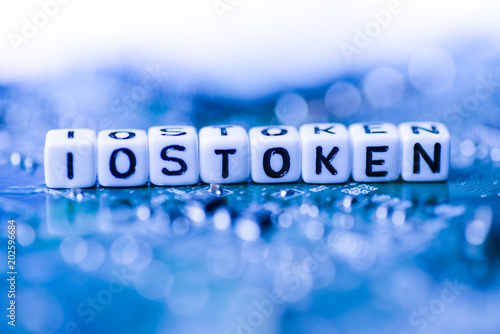 Word IOStoken formed by alphabet blocks on mother cryptocurrency photo