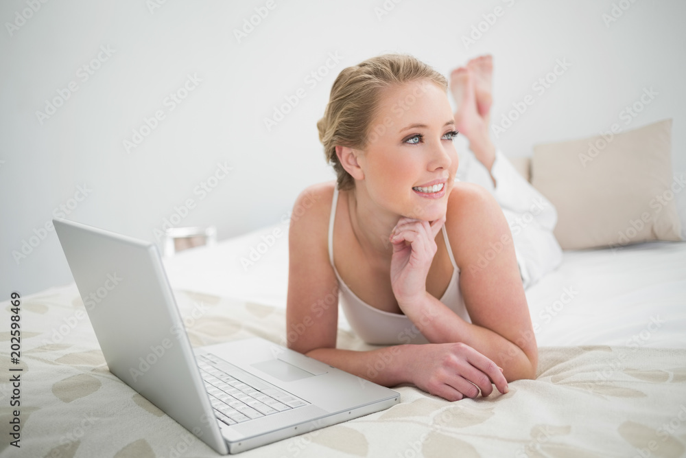 Natural content blonde using laptop and lying on bed Natural content blonde using laptop and lying on bed