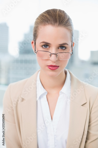 Serious businesswoman with glasses posing