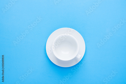 One White Empty Tea or Coffee Cup with Saucer on Light Blue Background. Top View. Mock up for Different Beverages Collage Element. Morning Breakfast Energy Caffeine Addiction Healthy Drinks Concept