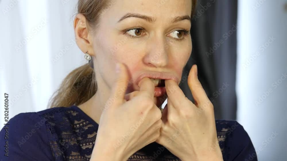blonde woman doing self-massage, anti-aging facial massage in office. daily face fitness and face building. blonde woman doing self-massage, anti-aging facial massage in office. daily face fitness and face building.