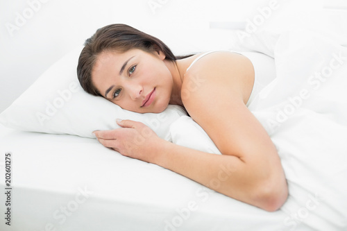 Beautiful young woman resting in bed