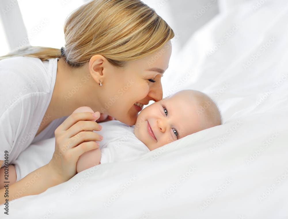 Family portrait of mom and baby in white bed. The concept of family. Family portrait of mom and baby in white bed. The concept of family.