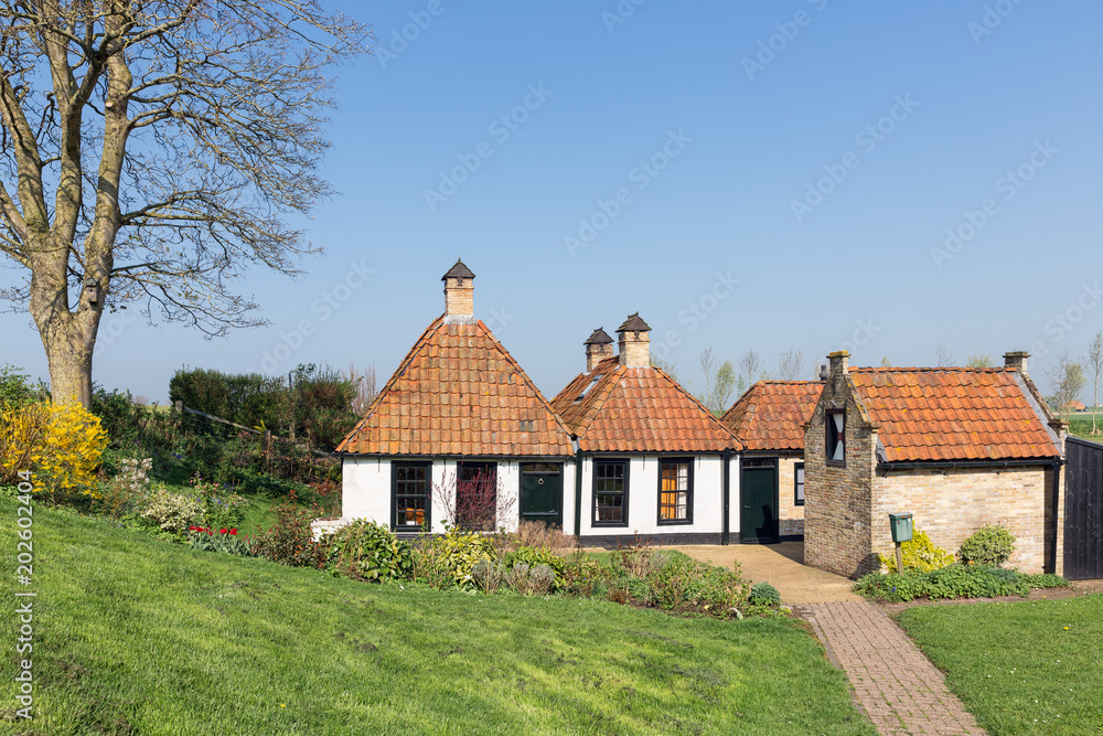 Φωτογραφία Tradtional Dutch countryside houses with garden near dike for protection to the