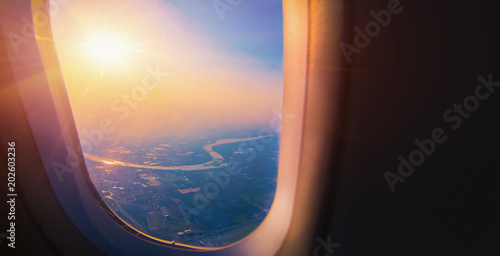 Aerial view from airplane window with the beautiful sky sunset and cloud.