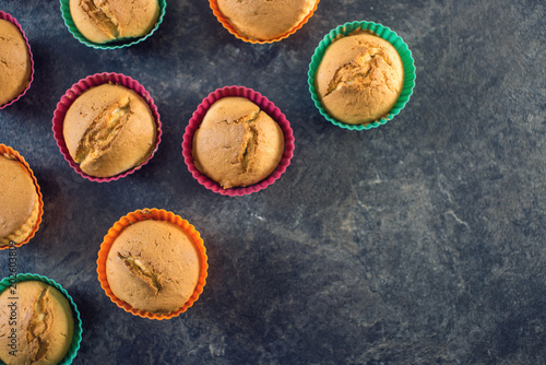 Homemade freshly made cupcakes in silicone molds on dark background. Top view. Concept of confectionery cooking