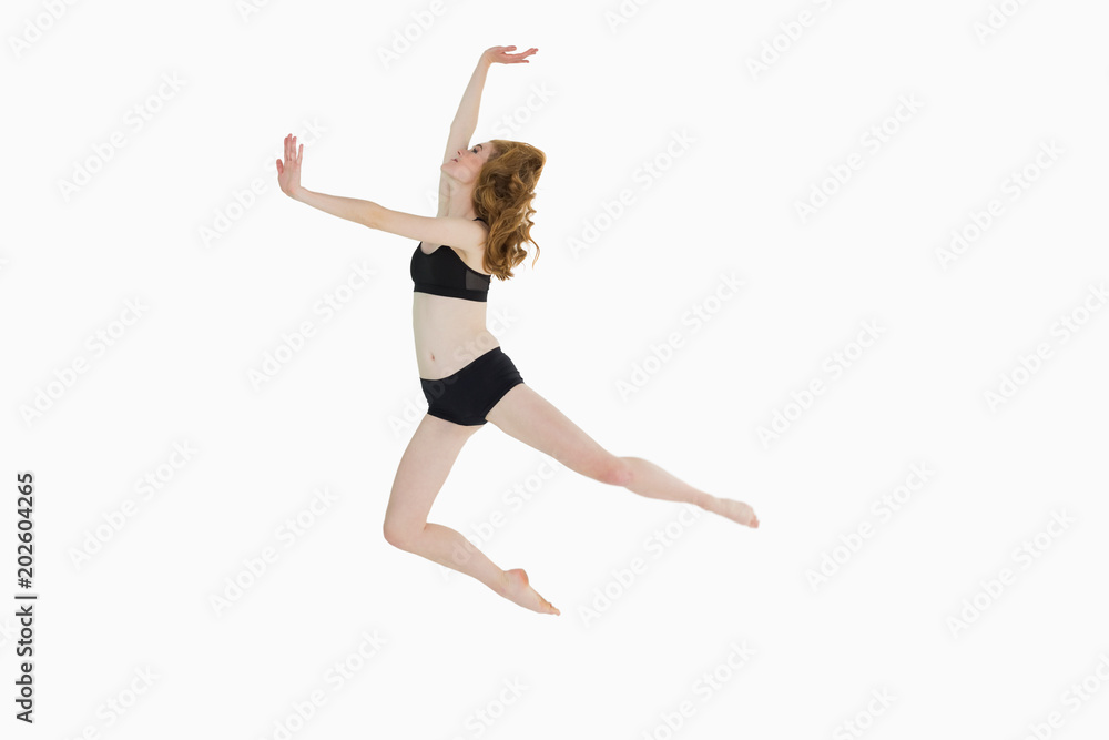 Full length side view of a sporty woman jumping Full length side view of a sporty woman jumping