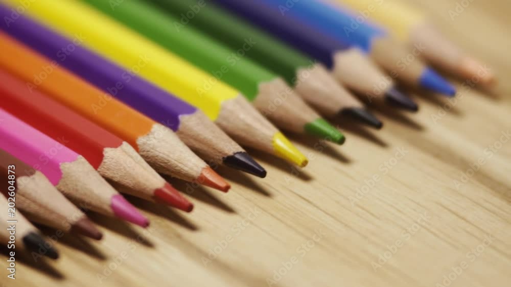 Colored pencils rotating on a wood background. Close up. Drawing and learning. Colorful background. Wood background Colored pencils rotating on a wood background. Close up. Drawing and learning. Colorful background. Wood background