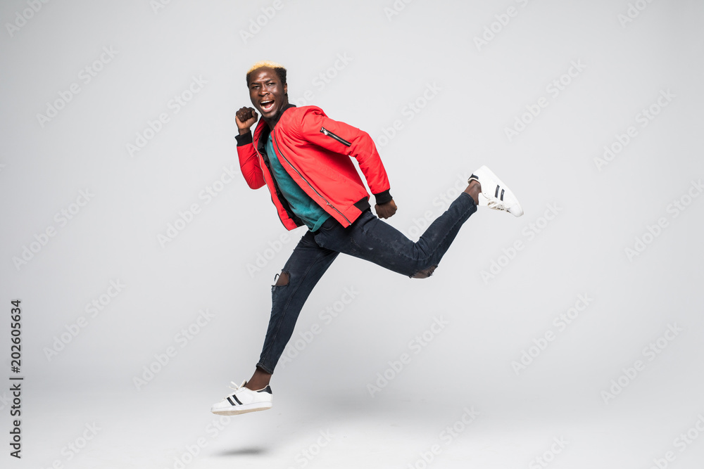 Φωτογραφία Full length portrait of a happy smiling african man running isolated over gray b