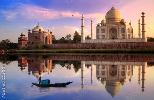 Taj Mahal Agra at sunset with wooden boat on river Yamuna.