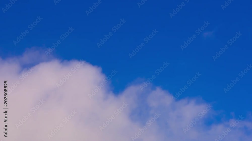 Time lapse summer white clouds fly across a bright blue sky Time lapse summer white clouds fly across a bright blue sky