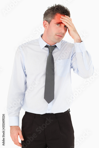 Portrait of a sad business manager with his hand on his forehead against a white background