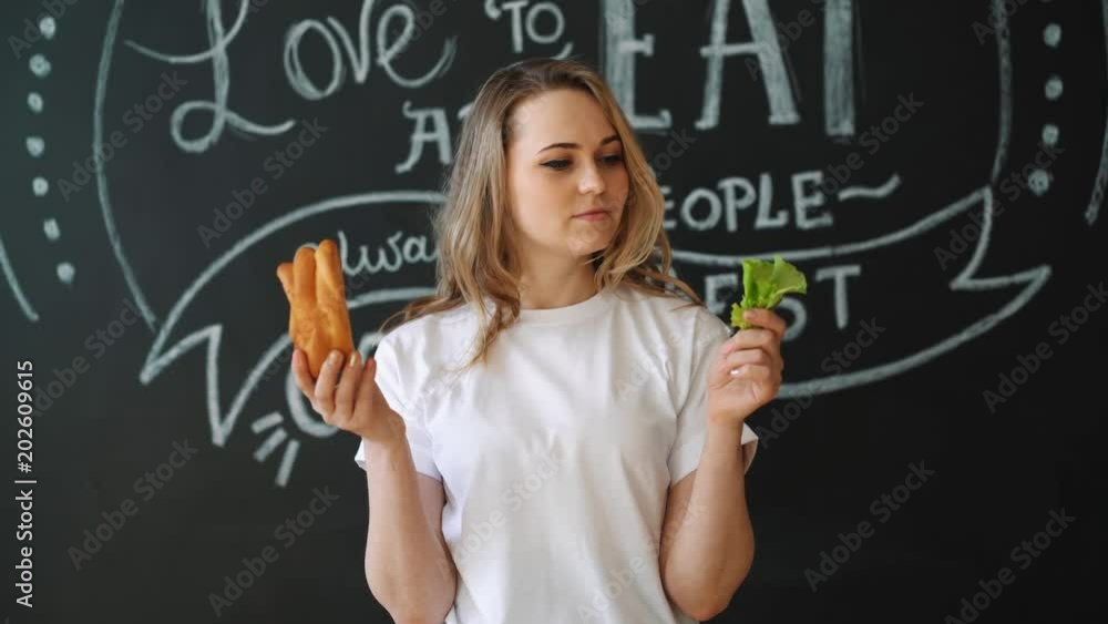 Healthy or harmful food, a girl before choosing a meal