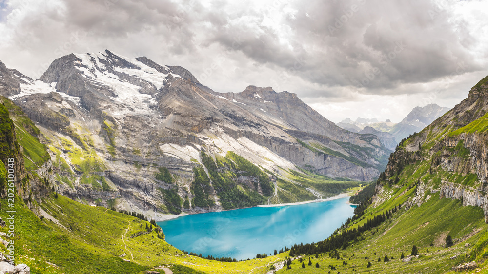 Oeschinen Lake in Swiss alps, clouds in the sky