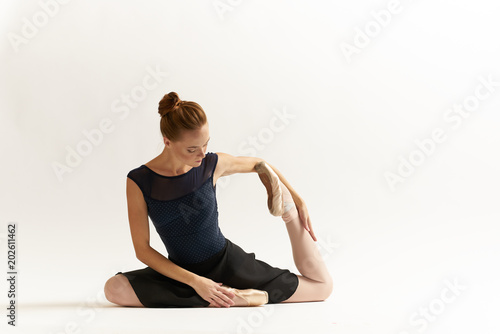 woman doing ballet stretching pointe shoes dress