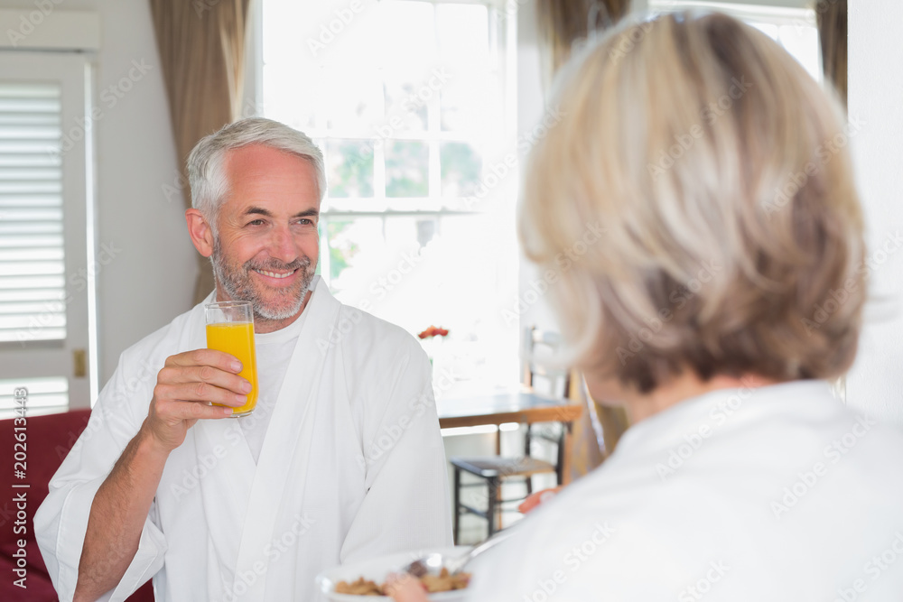 Smiling mature man having breakfast with cropped woman Smiling mature man having breakfast with cropped woman