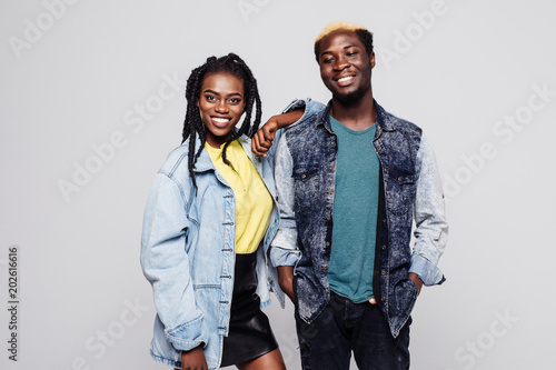 Afro american couple in casual clothes smiling at camera on white background