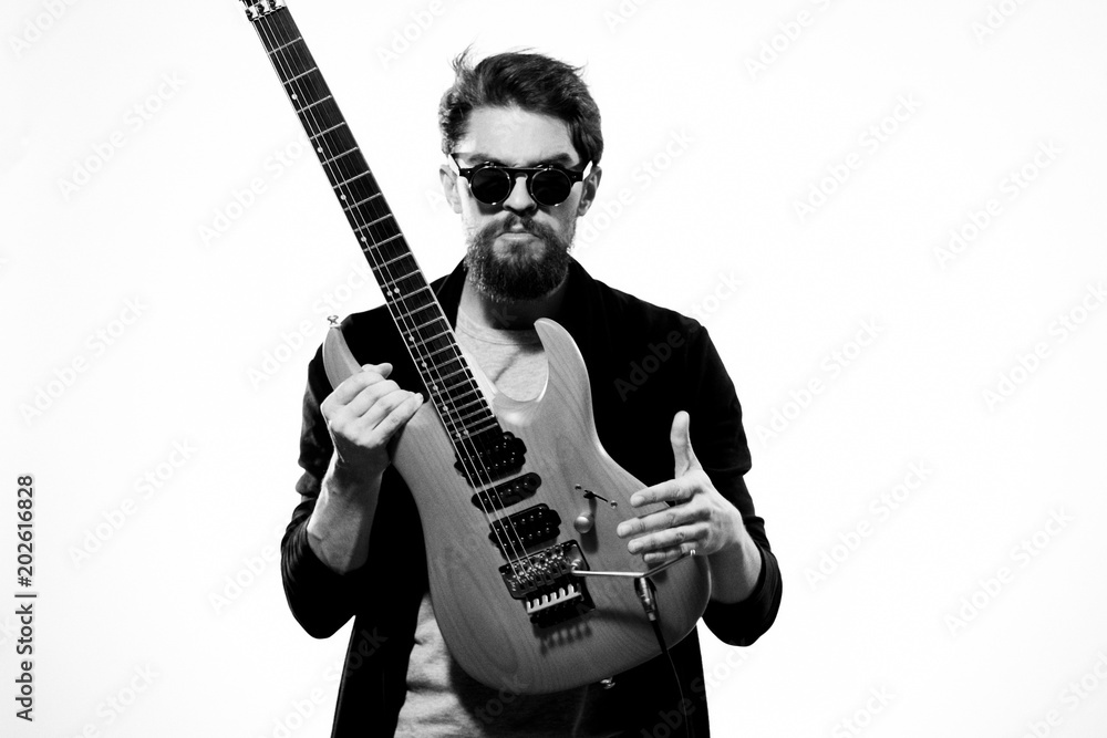 stylish man with glasses and a guitar in the foreground