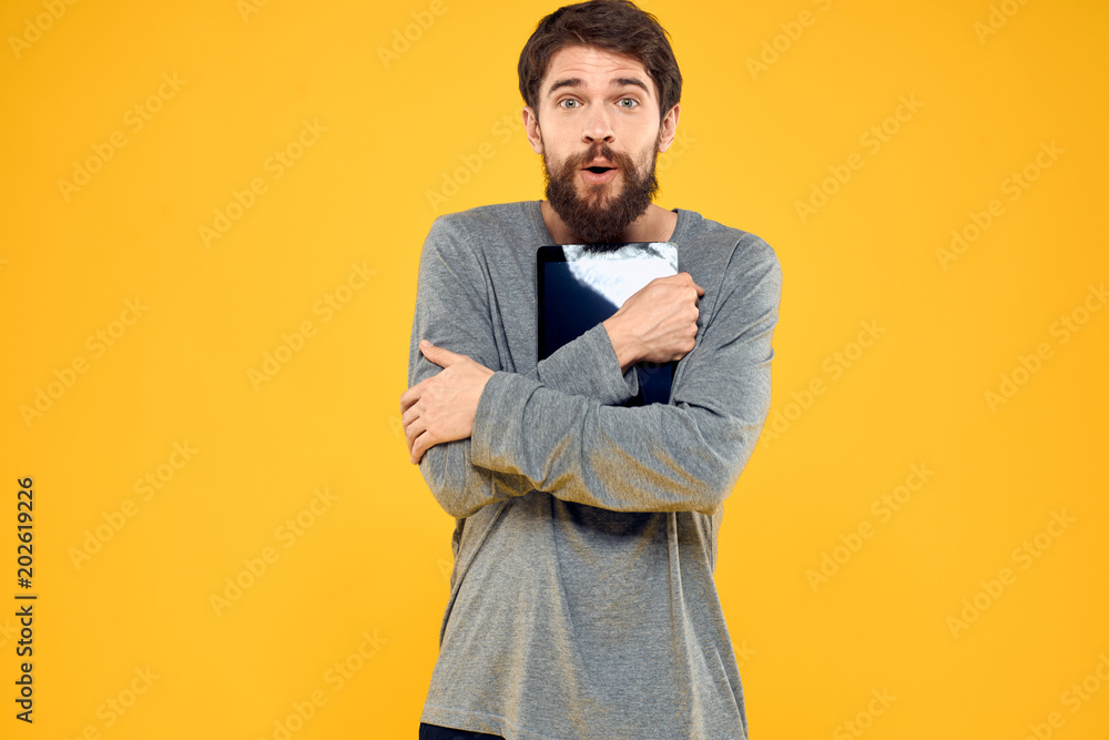 A man in a gray jacket pressed to his chest tablet