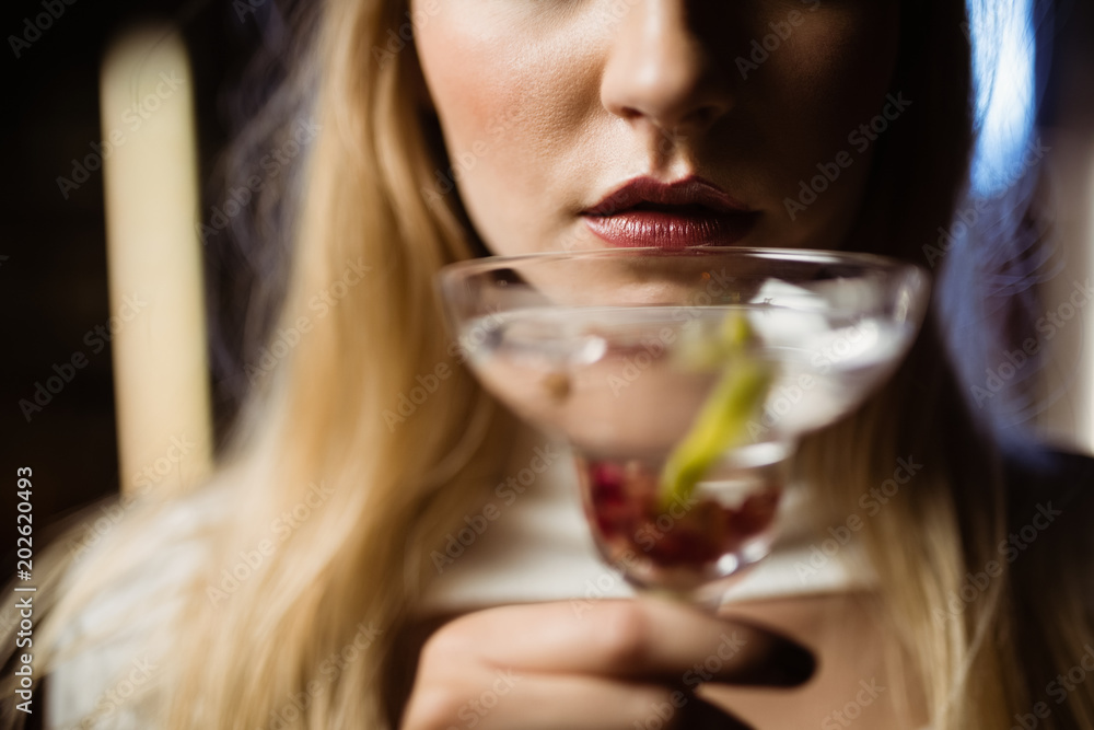 Midsection of woman holding martini glass Midsection of woman holding martini glass