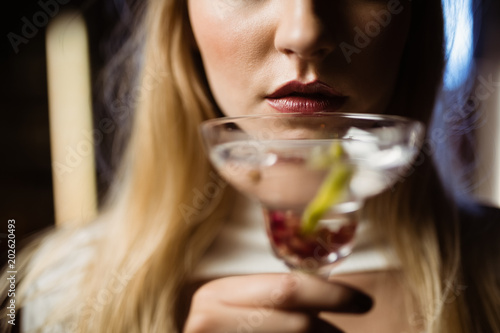 Midsection of woman holding martini glass