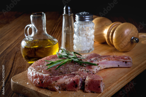 raw pork chop steak on wooden background.