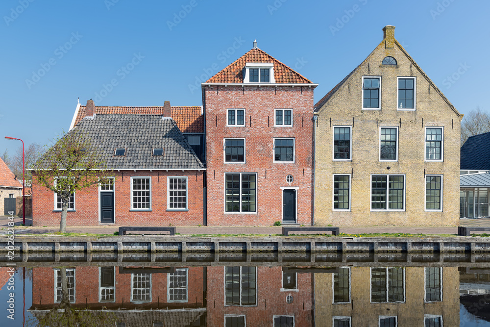 Facade of Houses along a canal in Makkum, an old Dutch village in Friesland