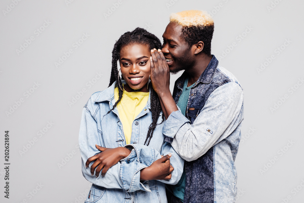 Portrait of a surprised young afro american couple telling secrets isolated over white background Portrait of a surprised young afro american couple telling secrets isolated over white background